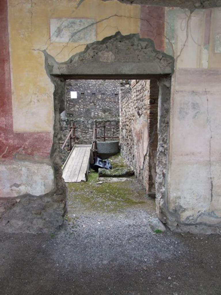 IX.8.6 Pompeii. March 2009. West portico, southern doorway in west wall leading to room 22. Against the north wall in room 22, are the remains of the lower stone step of the stairs to the upper floor, and an overturned lava stone.

