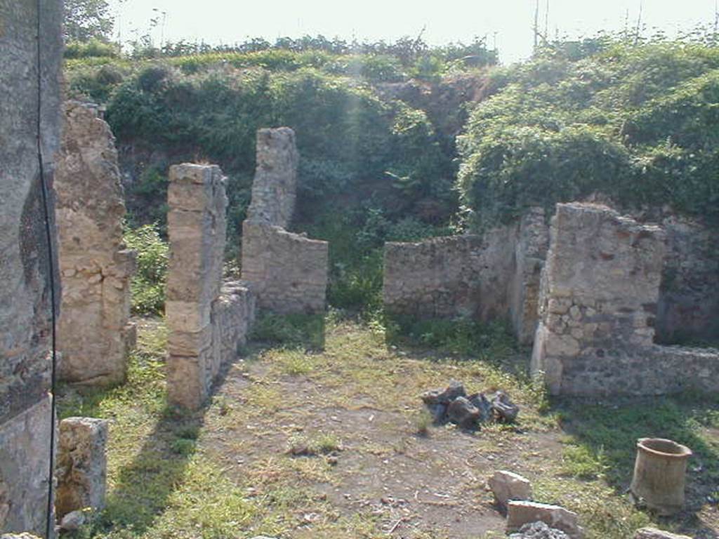 IX.8.c Pompeii.  May 2005.  Looking south along East Portico, with entrance to Triclinium on the left. The room on south side of garden area is on the right.   Photograph taken from IX.8.6.
