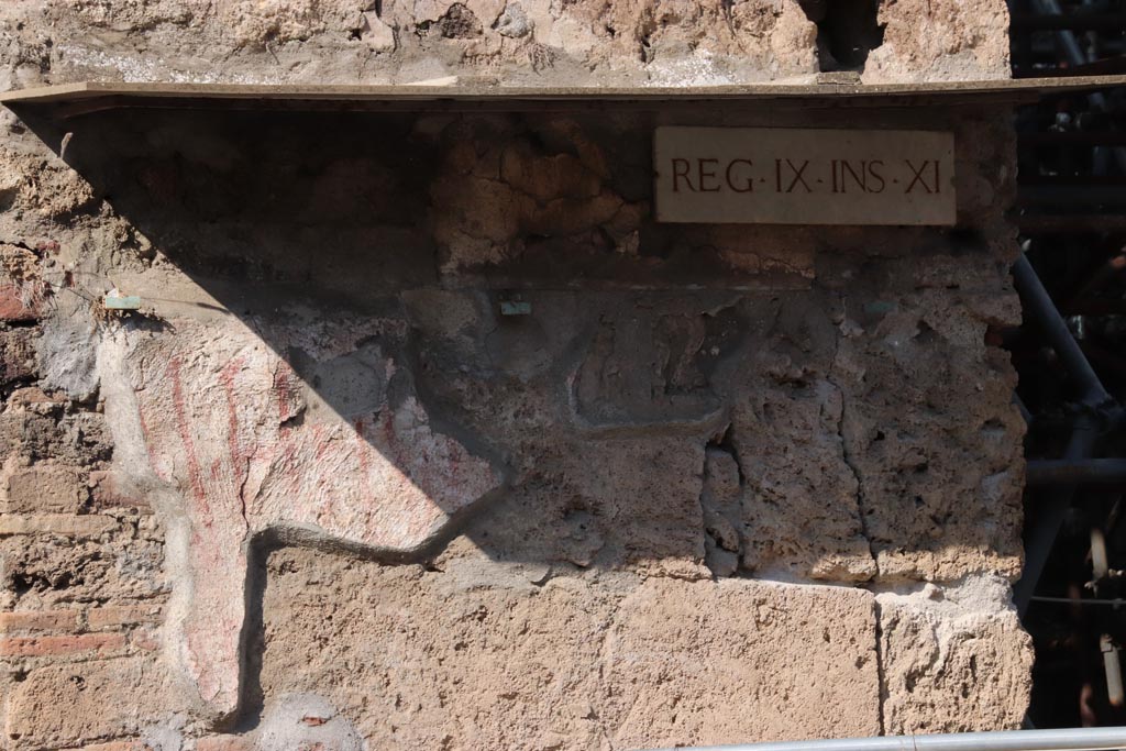 IX.11.8 Pompeii. October 2022. Remains of graffiti on front wall, east of doorway, at east end of insula. Photo courtesy of Klaus Heese. 