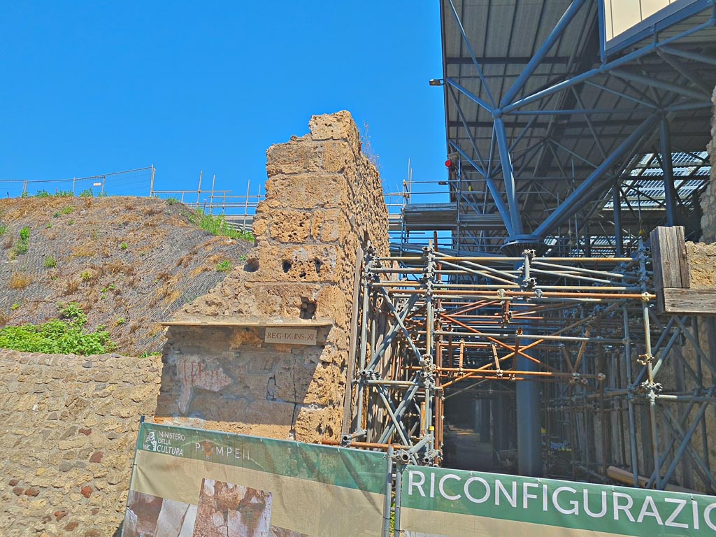 IX.11.8 Pompeii. June 2024. Via dell’Abbondanza, north side.
East pilaster of front façade with remains of painted inscription, at junction with an unnamed vicolo, on right. 
Photo courtesy of Giuseppe Ciaramella.