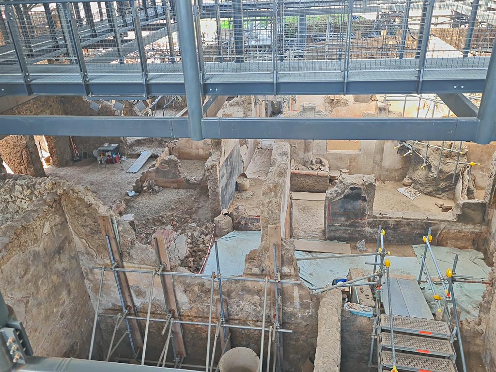 IX.12.6/4 Pompeii. June 2024. Looking west from above bakery in room “f”. 
The atrium of IX.12.4 (room “c”) is on the left, the rooms on the right (newly excavated) are also part of IX.12.4. 
Photo courtesy of Giuseppe Ciaramella.
