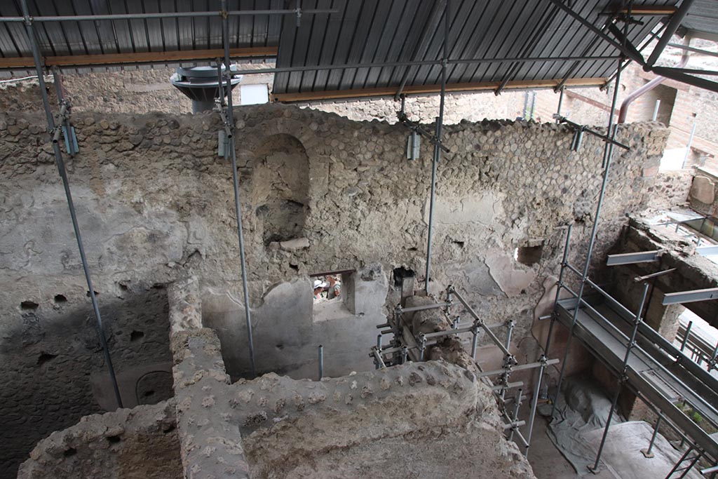 IX.12.7 Pompeii. October 2024. 
Looking towards east wall of shop “1” and rear room “2”, with niche [latrine?] in wall of upper room. Photo courtesy of Klaus Heese.

