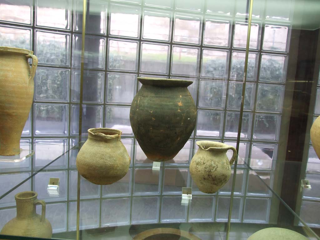 Finds from Villa Regina Boscoreale. December 2006. Now in Boscoreale Antiquarium.
According to the museum card, at the rear is a pot (Olla) from kitchen room 1.
To the left is an Attingitoio (dipper) from room II. To the right is a jug (Boccale) from storeroom XII.

