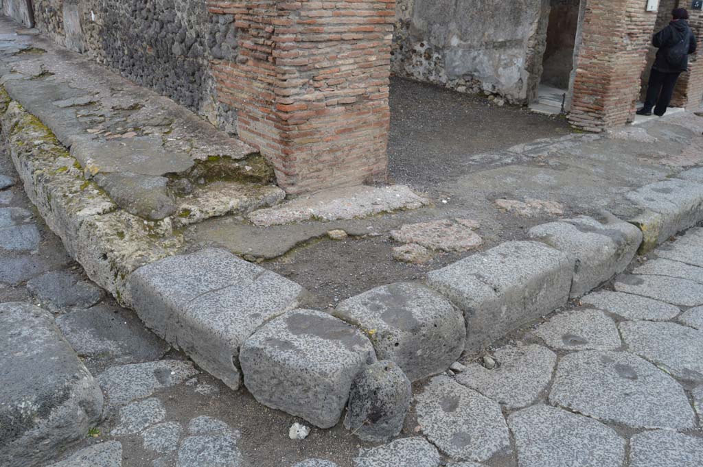 Via delle Terme, north side. March 2018. Looking north-east at junction with Vicolo della Fullonica with detail of lower wall and pavement. 
Foto Taylor Lauritsen, ERC Grant 681269 DÉCOR
