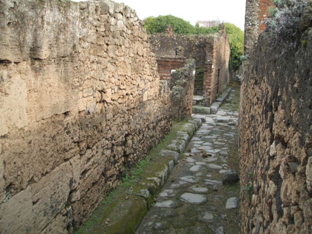 Vicolo degli Scheletri. December 2004. Looking east to crossroads with Vicolo di Eumachia between VII.9.62 and VII.10.1. 
