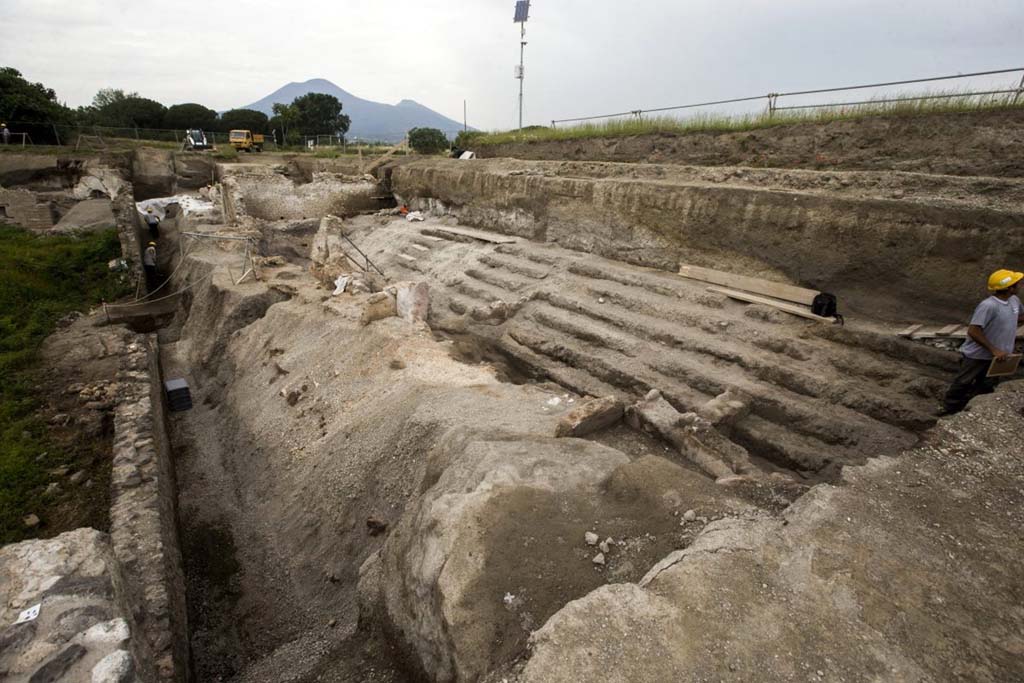 Vicolo dei Balconi, under excavation June 2018. 
This previously unnamed vicolo became known as Vicolo dei Balconi because, during the excavations, a number of houses with intact balconies were found at the north end on the east side of the vicolo, in V.3.

Vicolo dei Balconi, in fase di scavo giugno 2018.
Questo vicolo precedentemente senza nome divenne noto come Vicolo dei Balconi perché, durante gli scavi, un certo numero di case con balconi intatti sono stati trovati all'estremità nord sul lato est del vicolo, in V.3.

Photograph © Parco Archeologico di Pompei.
