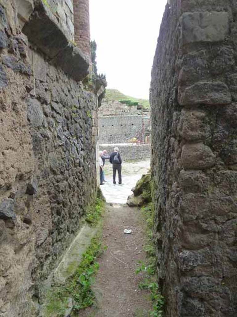 Pompeii Porta Nocera. May 2010. Tomb 7OS. Looking north from west side of tomb towards Via delle Tombe.
At the time of the eruption the tomb must have been abandoned for some time, cluttered with a layer of debris and without the closing door.
In front of the east side of the façade and of the connecting wall with the tomb 9OS, fourteen columellae, mostly of lava, were found, buried in the layer of debris and covered by it. In front of five of the columellae funerary urns were found.
See D’Ambrosio, A. and De Caro, S., 1983. Un Impegno per Pompei: Fotopiano e documentazione della Necropoli di Porta Nocera. Milano: Touring Club Italiano. (7OS)
