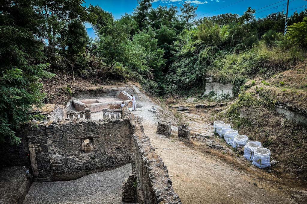 Porta Sarno la tomba di Marcus Venerius Secundio. August 2021. Looking south-east to new tomb opposite road area E. 
A hermetically sealed burial chamber can be seen at the front of the tomb. Tomb areas B and A are in the foreground. 

Guardando verso sud-est alla nuova tomba di fronte all'area stradale E. 
Un ambiente ermeticamente chiuso può essere visto nella parte anteriore della tomba. Le aree tombali B e A sono in primo piano.

Photograph © Parco Archeologico di Pompei.
