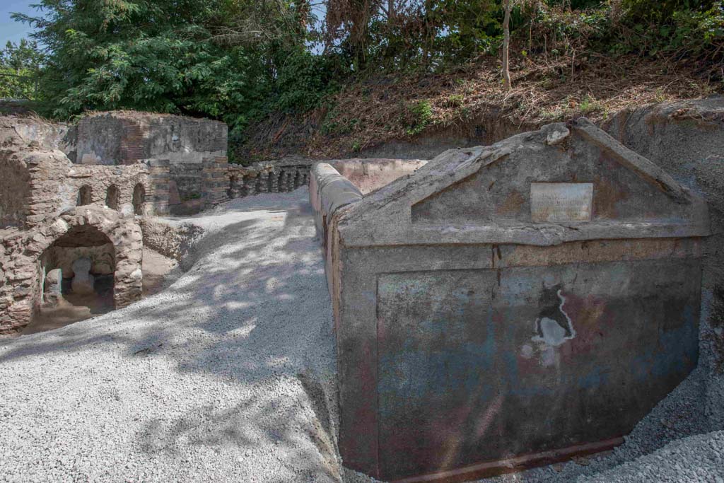 Porta Sarno la tomba di Marcus Venerius Secundio. August 2021. Looking past the front of the tomb to small arched tomb with two cippi.

Guardando oltre la parte anteriore della tomba fino alla piccola tomba ad arco con due cippi. 

Photograph © Parco Archeologico di Pompei.
