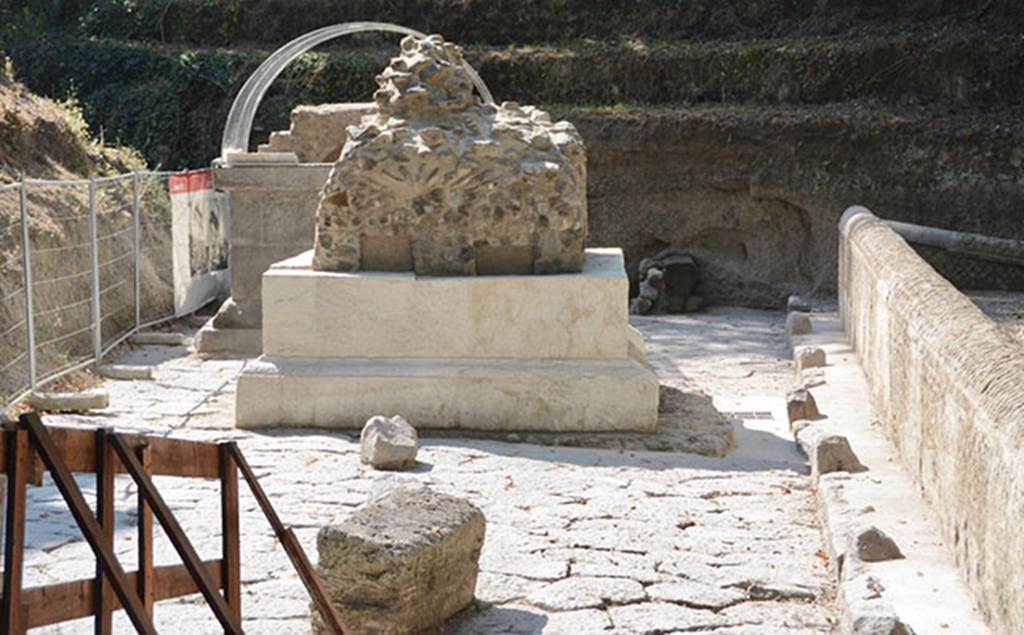 SG4 and SG5 Pompeii. 2018. Tomb SG4 is at the front with SG5 behind
These are two chamber tombs excavated in 2001 and located in an area bound by a pavement and a small plaster coated opus reticulatum wall.
Unusually the tombs appear to be placed in the middle of the road.
The road paving was entirely covered in a thick layer of alluvial deposits. 
The removal of this deposit layer revealed an unfinished sub-square masonry structure to the south of Tomb SG4. 
These likely relate to a third tomb, which was unfinished following the abandonment of the site, as the tuff and lava blocks which were discovered in the immediate vicinity and appeared ready to be used in construction would indicate, along with a pile of lava and small block chips.
See http://pompeiisites.org/en/comunicati/the-tombs-of-the-necropolis-of-porta-stabia/
