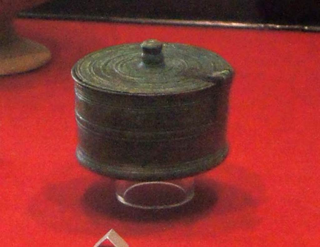 Gragnano, Villa rustica in Località Carmiano, Villa A. Room 9. 
Cylindrical bronze pyx (small round lidded box) with hinged lid and decorated with incised parallel lines. 
Stabiae Antiquarium, inventory number 63528.
Detail from photo courtesy of Margaret Hicks.
